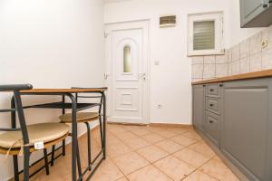 a kitchen with a table and chairs and a door at Apartments Ivan in Vinišće