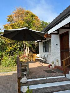 un patio con sombrilla frente a una casa en Brenton Bliss 3-N, en Brenton-on-Sea