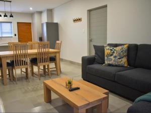 ein Wohnzimmer mit Sofa und Tisch in der Unterkunft 1 on York Townhouse 3 in George