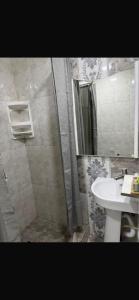 een badkamer met wastafel en douche met spiegel bij Any Home in Armavir