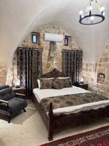 een slaapkamer met een groot bed en een stenen muur bij Katmani Hotel in Mardin