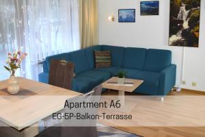 a blue couch in a living room with a table at Ferienhaus Albmatte-Naturidyll am Fluss-Novemberaktion-Sauna inklusive in St. Blasien