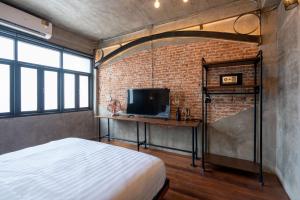 a bedroom with a bed and a brick wall at House of Machine Boutique Hotel in Bangkok