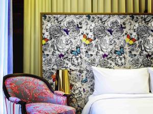 1 dormitorio con 1 cama, 1 silla y 1 pared en SO/ Sofitel Hua Hin, en Cha Am 232 fotos más