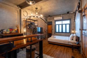 a bedroom with a bed and a desk in a room at House of Machine Boutique Hotel in Bangkok