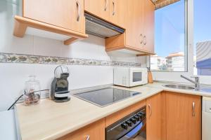 eine Küche mit Spüle und Mikrowelle in der Unterkunft Apartamento Con Parking Y Piscina in Castillo Bajo