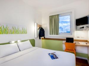 ポルト・アレグレにあるibis budget Porto Alegre - Super Econômicoのベッドと机と窓のある寝室