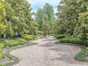 a gravel path in a garden with trees at The Sebel Bowral Heritage Park in Bowral