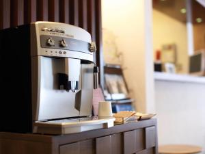 une machine à café assise au-dessus d'un comptoir dans l'établissement Hotel Areaone Kochi, à Kōchi