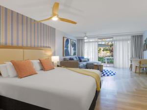 a bedroom with a large bed and a couch at The Sebel Palm Cove in Palm Cove +46 photos