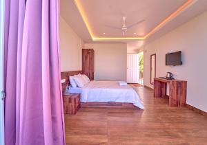 a bedroom with a bed with purple curtains at Gardenia Kanthalloor in Kanthalloor