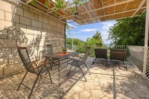a patio with a table and chairs on a brick wall at Helena in Mlini