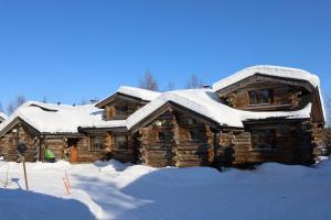 a log cabin with snow on top of it at Holiday Home Kantapää D1 in Luosto