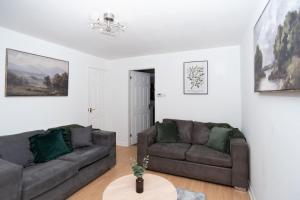 a living room with two couches and a table at Wellington - Telford house - With parking in Wellington