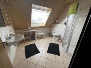 ein Badezimmer mit Dusche, Waschbecken und Toilette in der Unterkunft Haus Hanni Ferienwohnung Hanni in Hage Ostfriesland direkt am Kiessee und Kurpark - Nordseenah in Berumbur