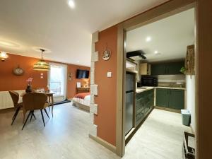 een keuken en eetkamer met groene kasten en een tafel bij Chtite Vosgienne Gîte 4 étoiles cosy in Vecoux