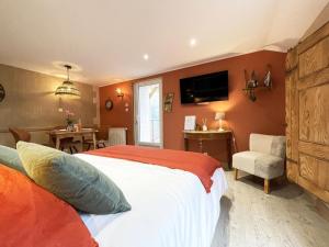 een slaapkamer met een bed, een stoel en een televisie bij Chtite Vosgienne Gîte 4 étoiles cosy in Vecoux