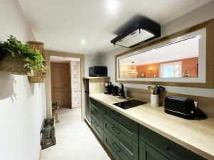 een keuken met een wastafel en een spiegel bij Chtite Vosgienne Gîte 4 étoiles cosy in Vecoux