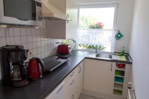 un comptoir de cuisine avec un évier et une fenêtre dans l'établissement Ferienhaus Stahlberg, à Babelsberg