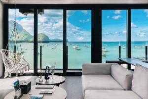 a living room with a view of the water and boats at H Hotel El Nido - Vegan Friendly Hotel Managed by H Hospitality Group in El Nido