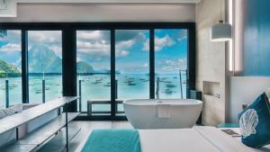 a bathroom with a tub and a view of the ocean at H Hotel El Nido - Vegan Friendly Hotel Managed by H Hospitality Group in El Nido