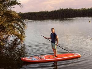 a man is standing on a paddle board in the water at EasyLife Villa Hội An in Tân Thành (1) +11 photos