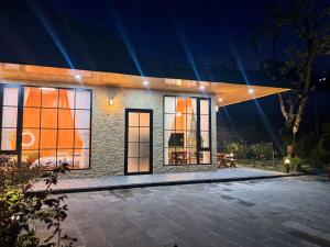 a house at night with a pool in front of it at Kem Rose Trại Mát in Trai Mat