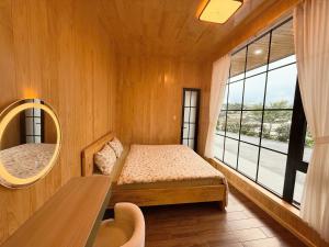a small bedroom with a bed and a mirror at Kem Rose Trại Mát in Trai Mat