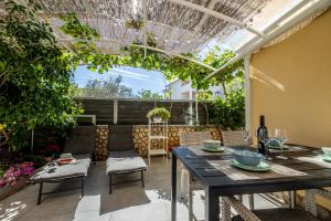 eine Terrasse mit einem Tisch, Stühlen und einer Pergola in der Unterkunft Studio für 2 Personen  2 Kinder ca 35 qm in Šilo, Kvarner Bucht Krk in Šilo