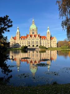 a large building sitting on top of a lake at Zweitbettzimmer Two-bed room in Hannover