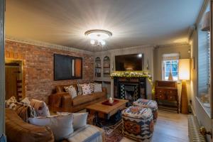 a living room with a couch and a fireplace at Cherry Trees Farmhouse in Nether Broughton