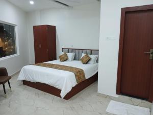 a bedroom with a large bed with white sheets and pillows at The Millennium Kashi Hotel in Varanasi +1 photo