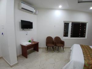 a hotel room with a bed and a desk and a tv at The Millennium Kashi Hotel in Varanasi