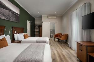 a hotel room with two beds and a flat screen tv at Protea Hotel by Marriott George King George in George +55 photos