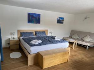 Un dormitorio con una cama grande y un sofá. en Modern Gemütlich, en Pflach