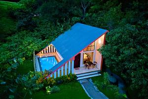an overhead view of a small house with a blue roof at Maryland Nature Stay Wayanad by VOYE HOMES in Wayanad