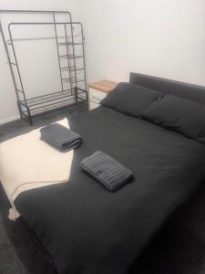a black bed with two folded towels on it at Nobles Nest in Skegness