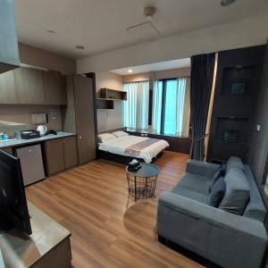 a living room with a couch and a bed at Prague Hostel in Kaohsiung