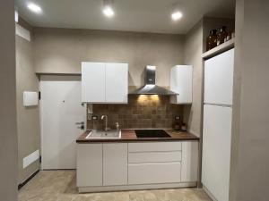 a kitchen with white cabinets and a sink at La casetta in Varazze