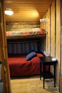 a bedroom with two bunk beds in a log cabin at Holiday Home Hopukka F12 in Luosto