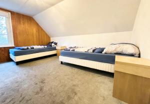 FriedeburgGroot Appartement - 10 Personen - 4 Slaapkamers - Perfect voor Teams & Monteurs - Friedeburg的有两张床和一扇窗户的卧室