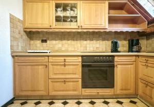 FriedeburgGroot Appartement - 10 Personen - 4 Slaapkamers - Perfect voor Teams & Monteurs - Friedeburg的厨房配有木制橱柜和烤箱。 更多12张照片