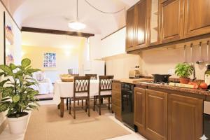 a kitchen with wooden cabinets and a table with chairs at da Patrick in Costarainera
