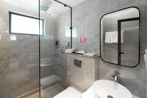 a bathroom with a shower and a sink and a mirror at celestia by thoppil in Kottakkal