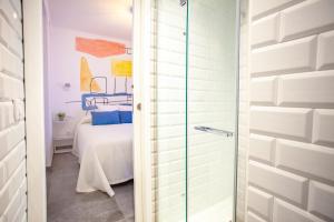 ein Badezimmer mit einer Glastür, die zu einem Schlafzimmer führt. in der Unterkunft Lukanda Hospec Olehousing in Sevilla