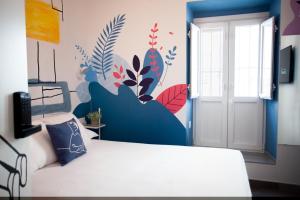 Un dormitorio con una cama con un mural en la pared. en Lukanda Hospec Olehousing, en Sevilla 42 fotos más
