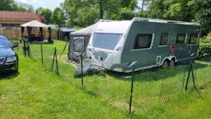 einem grünen und weißen Wohnwagen auf einem Feld in der Unterkunft Klimatisierter exklusiver Caravan mit 240 m umzäunten Stellplatz in Untergriesbach