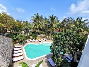 an overhead view of a pool with lounge chairs and palm trees at Thami House in Watamu