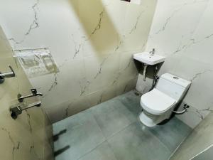 ein Badezimmer mit Toilette und Waschbecken in der Unterkunft Texas 3 BHK villa for 13 pax near Airport in Thiruvananthapuram