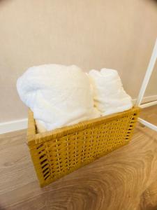 ein Korb mit weißen Handtüchern auf einem Holzboden in der Unterkunft Schöne 2 Zimmer Wohnung Apartment Holzappel Herthasee Ferienwohnung in Holzappel